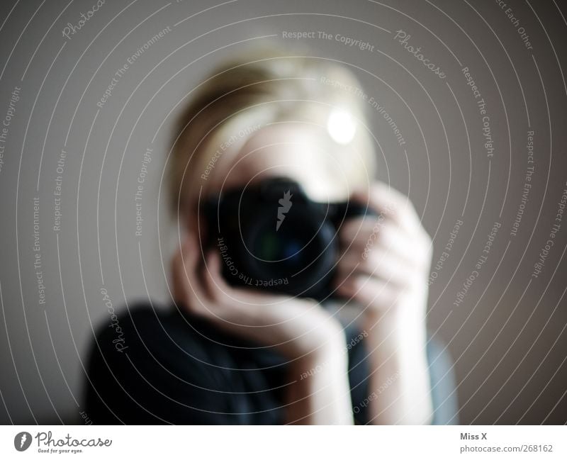 postural mark Human being 1 Blonde To hold on Photography Photographer Take a photo Camera Colour photo Subdued colour Reflection Blur Looking into the camera