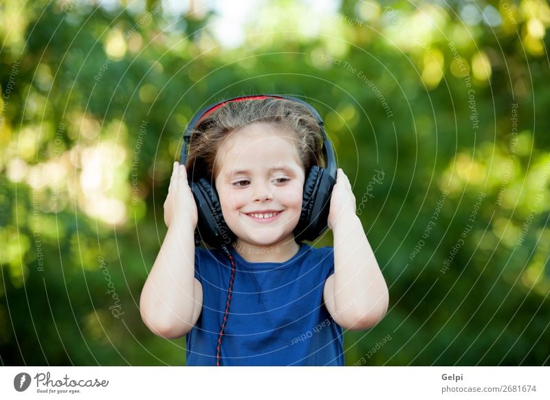 Little girl with headphones outside Lifestyle Joy Happy Beautiful Leisure and hobbies Playing Summer Music Child Technology Human being Woman Adults Infancy