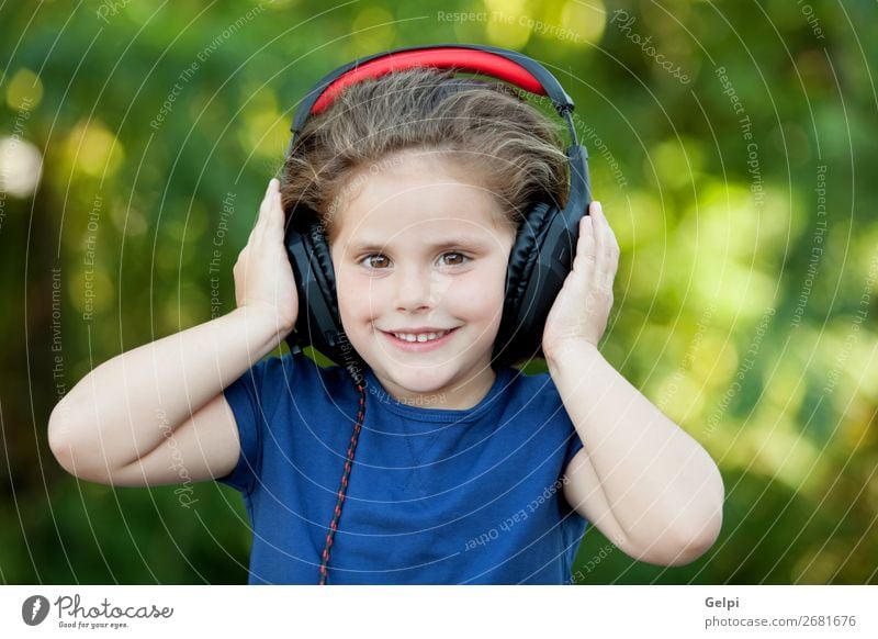 Little girl with headphones outside Lifestyle Joy Happy Beautiful Leisure and hobbies Playing Summer Music Child Technology Human being Woman Adults Infancy