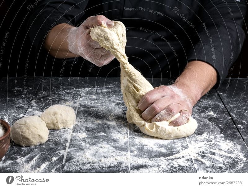 chef kneads dough made of white wheat flour Dough Baked goods Bread Nutrition Skin Table Kitchen Human being Man Adults Hand Wood Make Black White Tradition