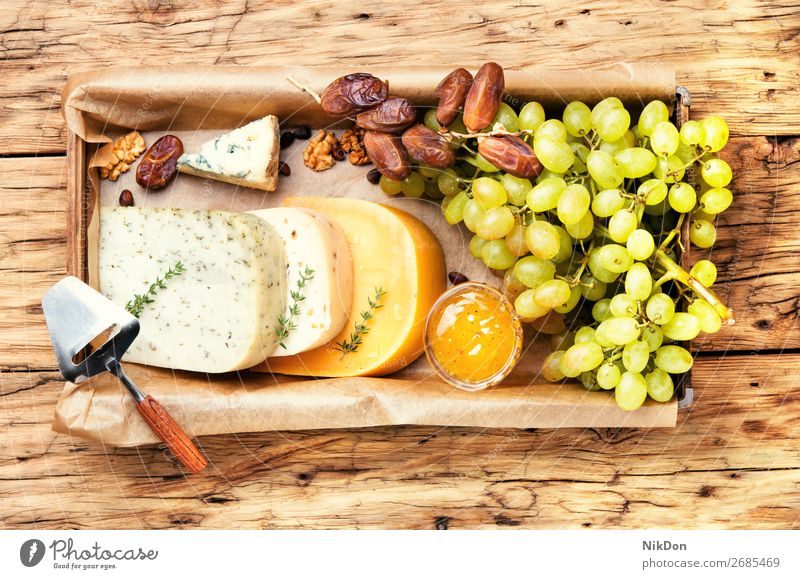 cheese and grapes board dairy slice brie walnut french delicatessen breakfast Swiss table italian cheeseboard goat assortment various knife portion cheddar