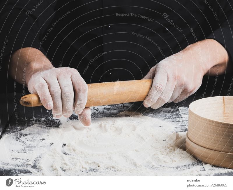 wooden rolling pin in men's hands Dough Baked goods Bread Table Kitchen Work and employment Cook Human being Hand Wood Black Rolling pin chef Flour Baking