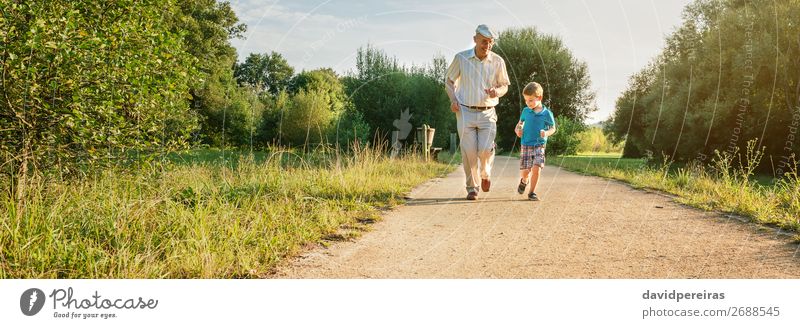 Senior man and happy child running on nature path Joy Happy Playing Child Human being Boy (child) Man Adults Grandfather Family & Relations Infancy Nature Tree