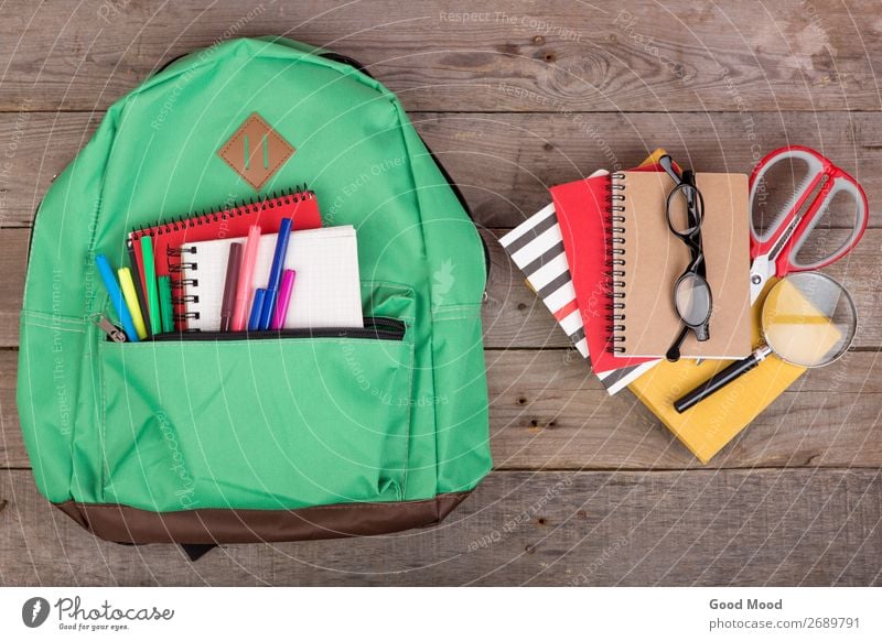 Backpack and school supplies: books, magnifying glass, notepad Table Child School Academic studies Tool Scissors Eyeglasses Magnifying glass Wood Brown Green