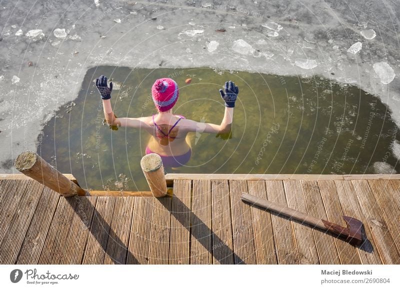 Fit woman performs ice swim in the ice hole. Lifestyle Healthy Alternative medicine Athletic Swimming & Bathing Leisure and hobbies Adventure Winter