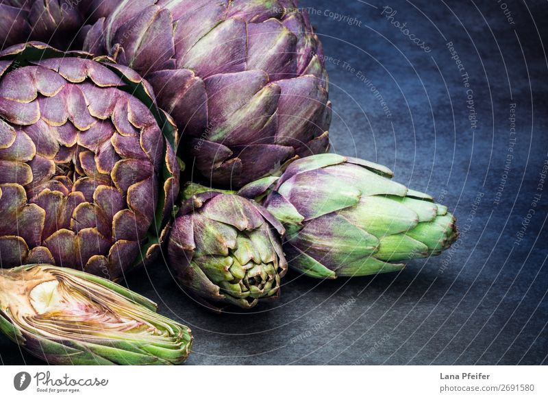 Artistic display of assorted artichokes Vegetable Nutrition Organic produce Healthy Eating To enjoy Background picture dark detailed fresh in section whole
