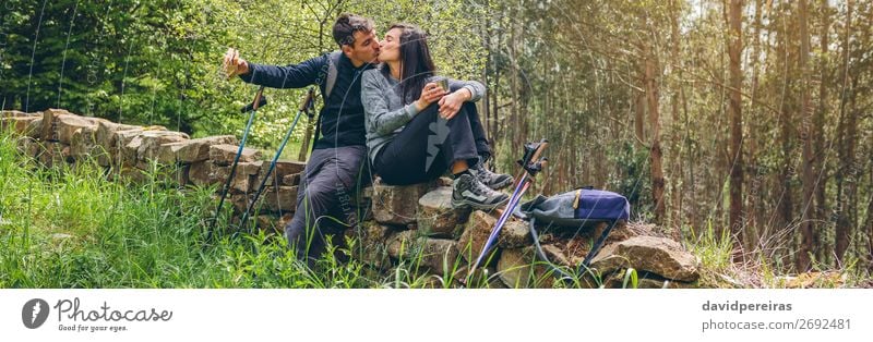 Couple kissing while making a break to do trekking Eating Drinking Lifestyle Leisure and hobbies Adventure Mountain Hiking Sports Climbing Mountaineering