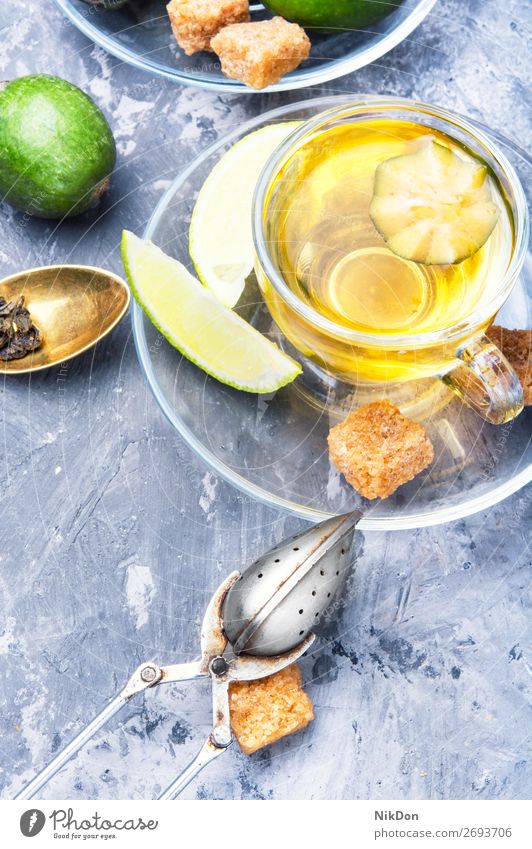 Tea with lime and feijoa tea blue glass green drink beverage healthy water cup hot natural citrus fruit warm relaxation autumn spoon sugar therapeutic calming
