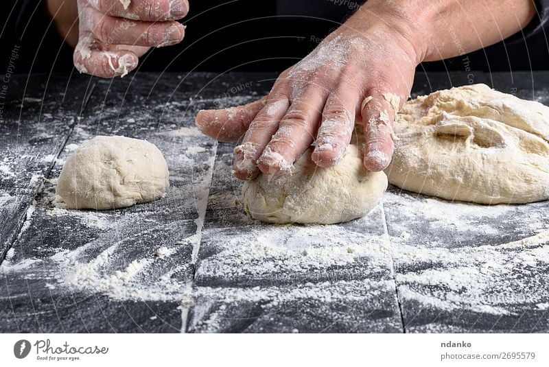 cook making dough balls on a black wooden table Dough Baked goods Bread Nutrition Skin Table Kitchen Cook Human being Man Adults Hand Wood Make Black White