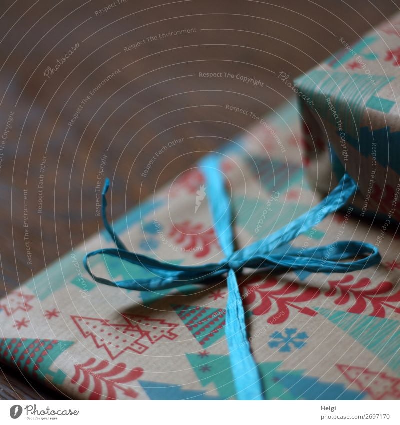Close-up of a gift wrapped in Christmas paper with ribbon and bow made of raffia Feasts & Celebrations Christmas & Advent Decoration Bow Gift Gift wrapping