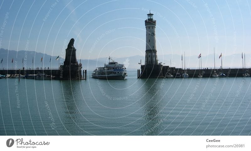 Lake Constance entrance Lindau Watercraft Lighthouse Lion Statue Wall (barrier) Jetty Reflection Driving Drop anchor Europe Germany Blue Harbour Island Mountain