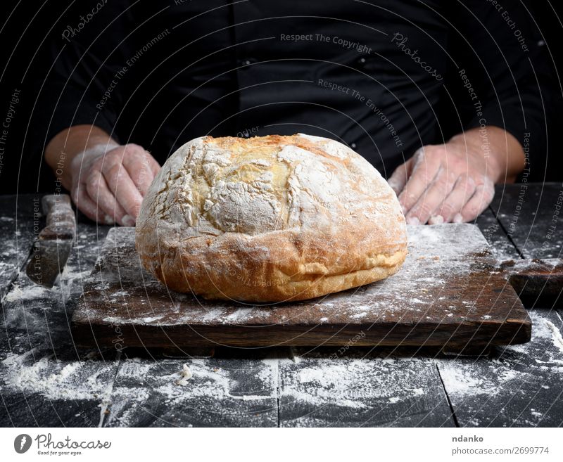 round baked homemade bread Dough Baked goods Bread Knives Table Kitchen Profession Cook Hand Wood Eating Make Dark Fresh Brown Black White Tradition Preparation