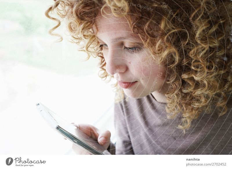 portrait of a young woman looks at her smartphone Style Beautiful Hair and hairstyles Skin Face Telephone Cellphone PDA Technology Entertainment electronics