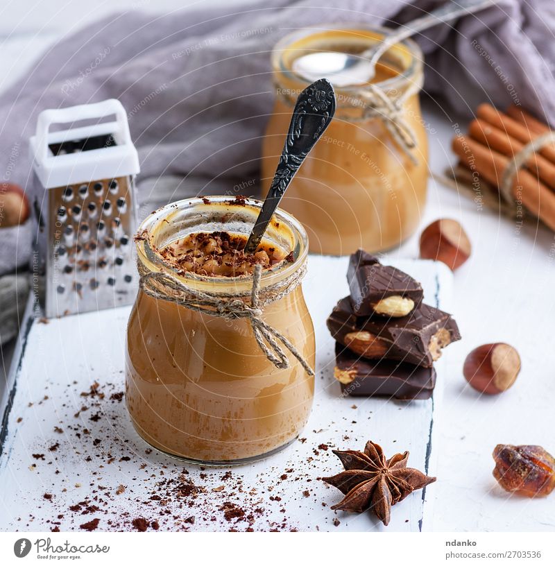 Caramel dessert Toffee in a glass jar Dessert Candy Herbs and spices Spoon Table Wood Fresh Delicious Brown cup background cream food Home-made Ingredients
