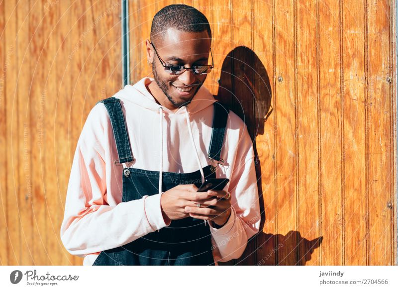 Young black man using smart phone outdoors Lifestyle Happy Beautiful Telephone PDA Technology Human being Masculine Young man Youth (Young adults) Man Adults 1