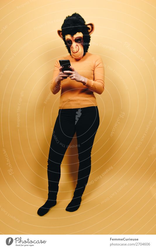 Woman with monkey mask looking at her smartphone Technology Entertainment electronics Telecommunications Feminine Adults 1 Human being 18 - 30 years