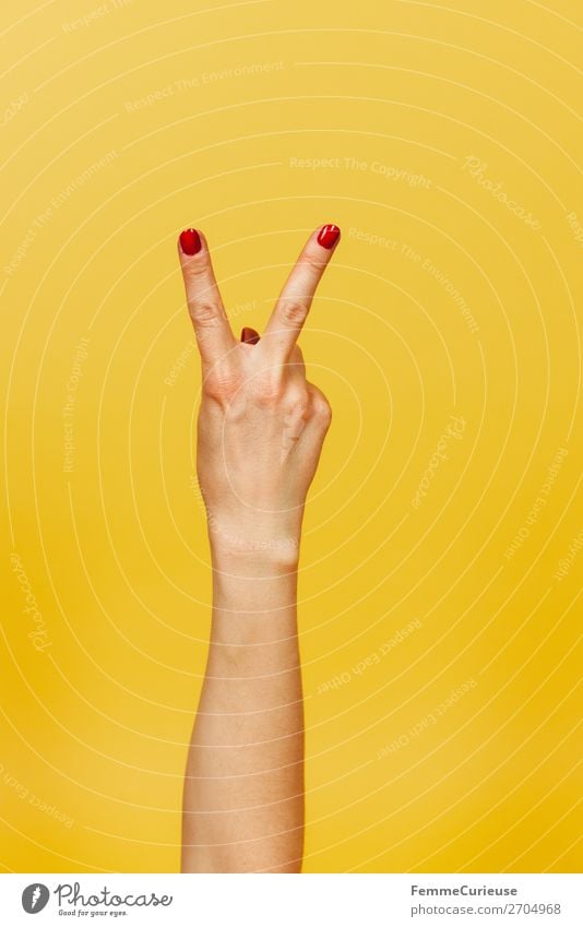 Hand signal for peace against a yellow background Feminine Woman Adults 1 Human being 18 - 30 years Youth (Young adults) 30 - 45 years Communicate Peace Sign