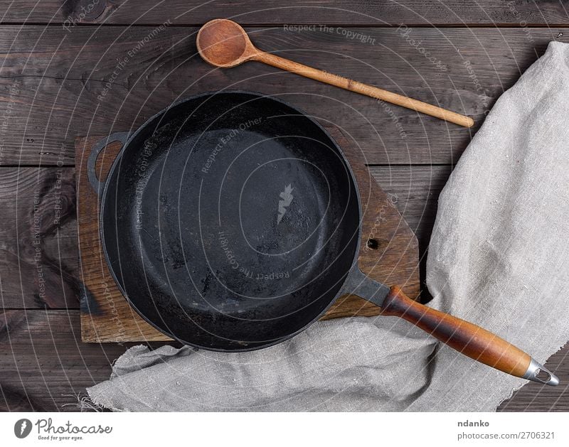 empty black round pan with wooden handle Dinner Pan Spoon Table Kitchen Wood Metal Old Dark Above Clean Black Frying background iron Cast Vantage point skillet