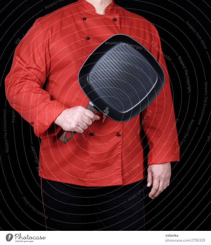 cook in red uniform holding an empty square black frying pan Pan Kitchen Restaurant Profession Cook Human being Hand Red Black Uniform single-breasted coat