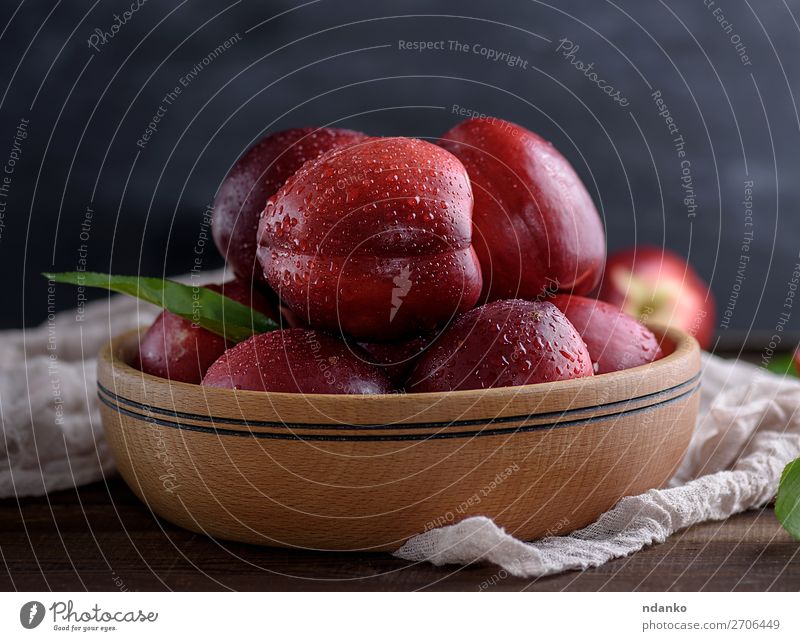ripe red peaches in a wooden bowl on a table Fruit Dessert Nutrition Vegetarian diet Diet Juice Bowl Table Nature Leaf Wood Fresh Natural Juicy Yellow Green Red