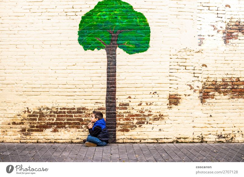 Little kid seated under a tree painted on a wall Joy Happy Beautiful Playing Adventure Winter Garden Climbing Mountaineering Child Human being Baby Toddler