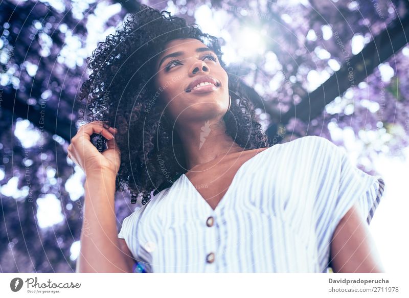 Young black woman surrounded by flowers Woman Blossom Spring Lilac Portrait photograph multiethnic Black African Mixed race ethnicity Smiling backlit from below