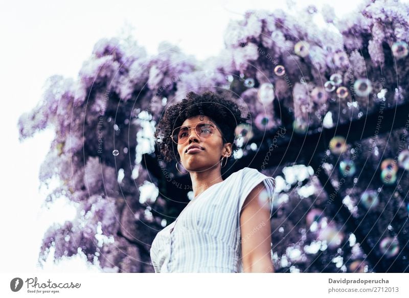 Happy young black woman surrounded by flowers Woman Blossom Spring Lilac Portrait photograph multiethnic Flower Black African Mixed race ethnicity Smiling
