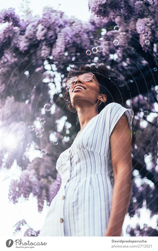 Happy young black woman surrounded by flowers Woman Blossom Spring Lilac Portrait photograph multiethnic Flower Black African Mixed race ethnicity Smiling