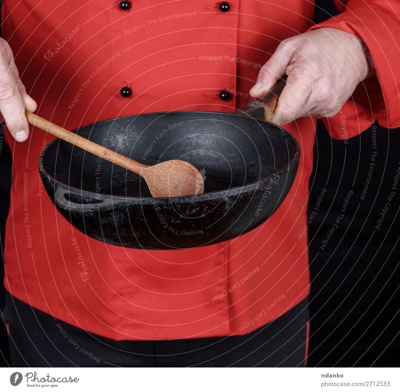 cook in red uniform holding an empty black frying pan Pan Spoon Kitchen Restaurant Profession Cook Human being Man Adults Hand Clothing Red Black Cast iron