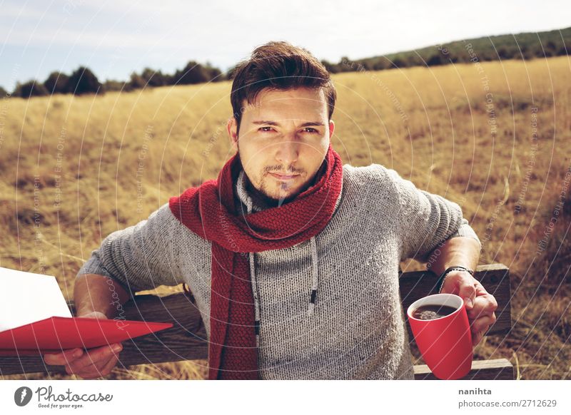 Handsome man reading a book in his holidays Coffee Lifestyle Relaxation Leisure and hobbies Reading Freedom Summer Man Adults Book Autumn Field Scarf Beard