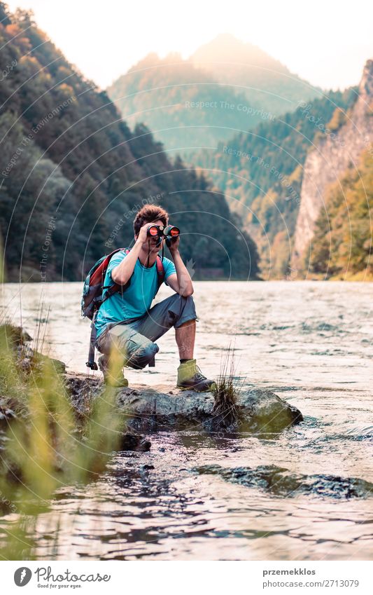 Young tourist with backpack looks through a binoculars Lifestyle Leisure and hobbies Vacation & Travel Trip Summer Mountain Human being Boy (child) Young man