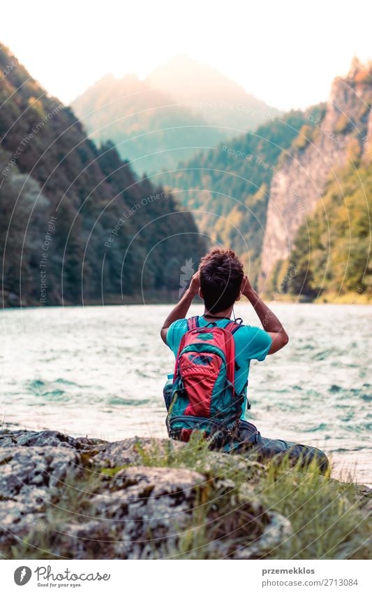 Young tourist with backpack looks through a binoculars Lifestyle Leisure and hobbies Vacation & Travel Trip Summer Mountain Human being Boy (child) Young man