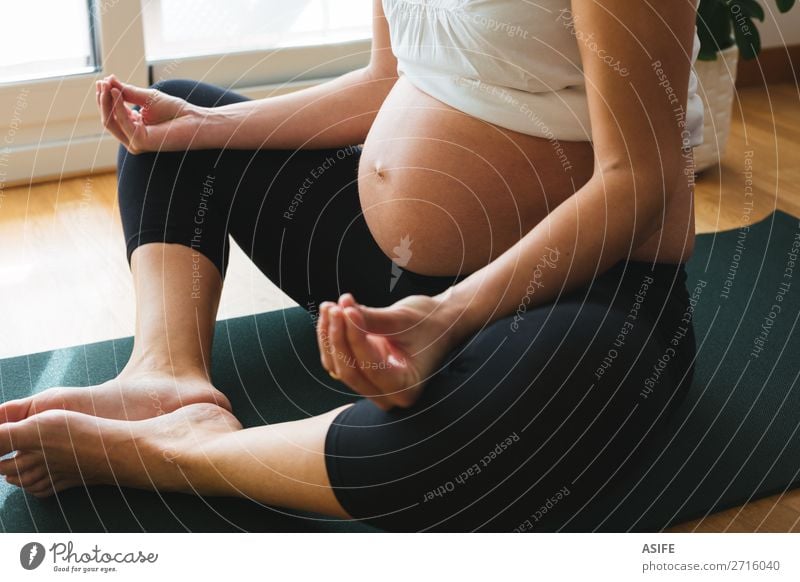 Pregnant woman doing yoga at home Happy Body Relaxation Sports Yoga Baby Woman Adults Parents Mother Fitness Green Future pregnancy Practice Lotus position Home