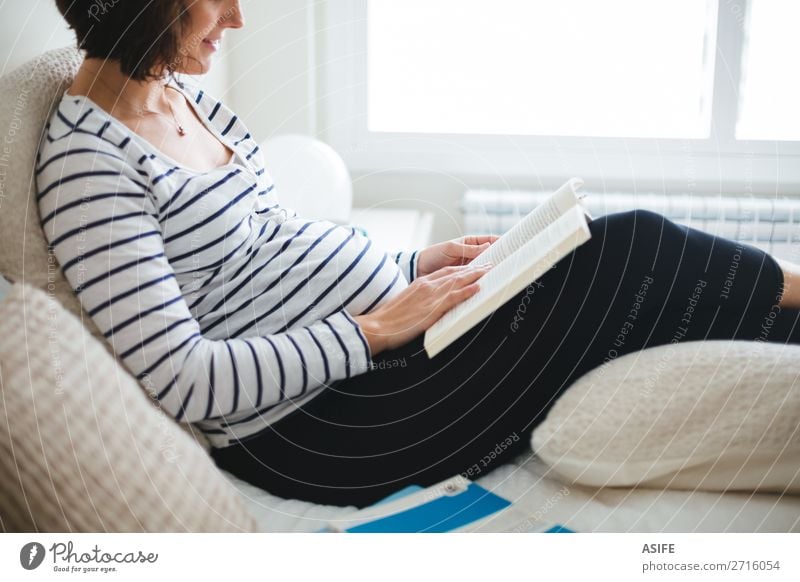 Pregnant woman reading a pregnancy book on the bed Happy Beautiful Body Relaxation Leisure and hobbies Reading Bedroom Baby Woman Adults Parents Mother Book Sit