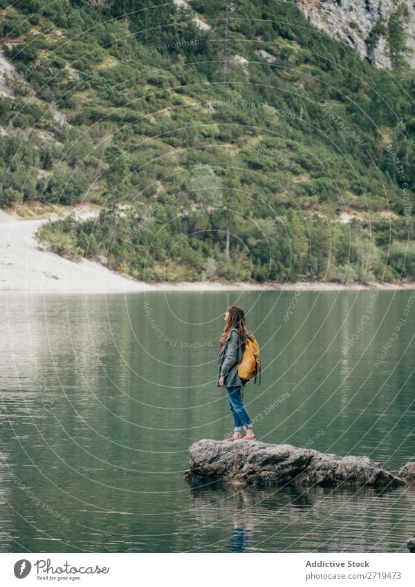 Female backpacker on stone in lake Woman Backpack Lake Mountain Tourism Landscape Action Freedom Tourist Adventure Nature Stone Posture Water Ripple