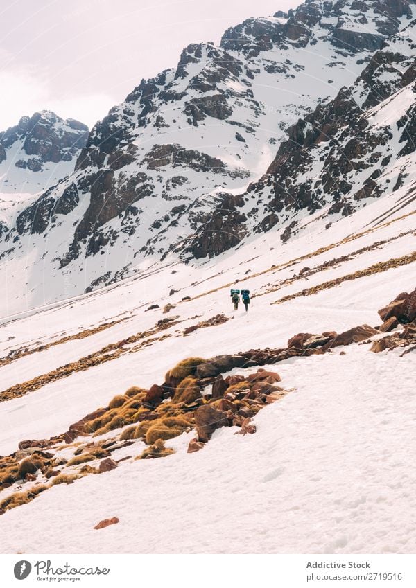 People walking on snowy slope of mountains Human being Mountain Tourism Winter Landscape Rock trekking Hiking Snow Lanes & trails Walking Vacation & Travel