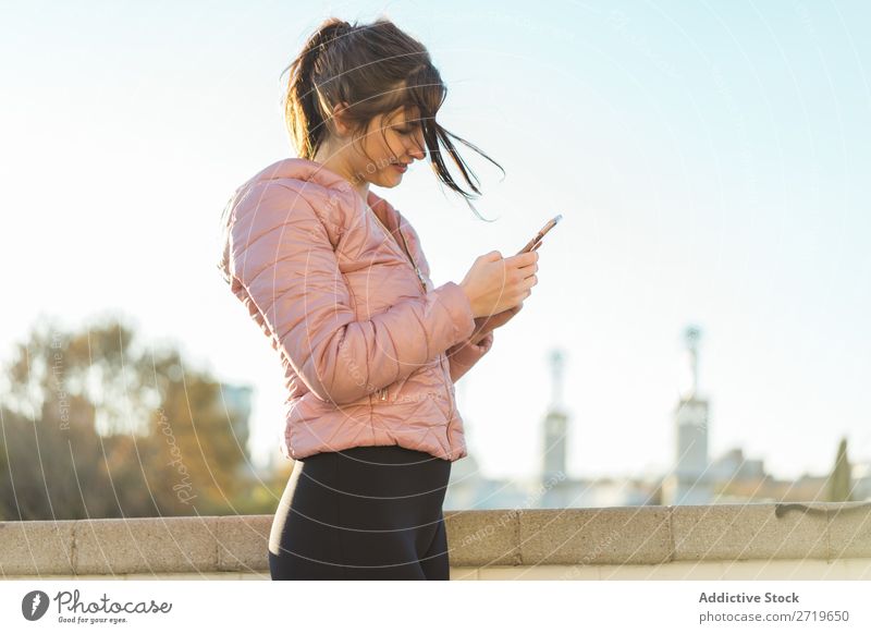 Pretty woman standing with smartphone on street Woman pretty PDA Park Happy Beautiful Telephone Youth (Young adults) Mobile Smiling Attractive Lifestyle Nature