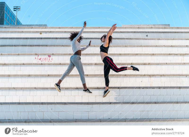 Pretty fit women jumping together Woman Athletic Together pretty Youth (Young adults) Cheerful Smiling Steps Jump Stretching Beautiful Sports multiethnic
