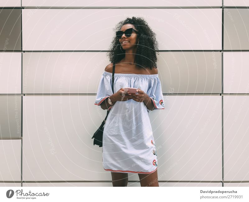 Cheerful black woman with mobile phone Woman Wall (building) Adults Easygoing PDA African Ethnic Cellphone Copy Space Youth (Young adults) Lifestyle pastel
