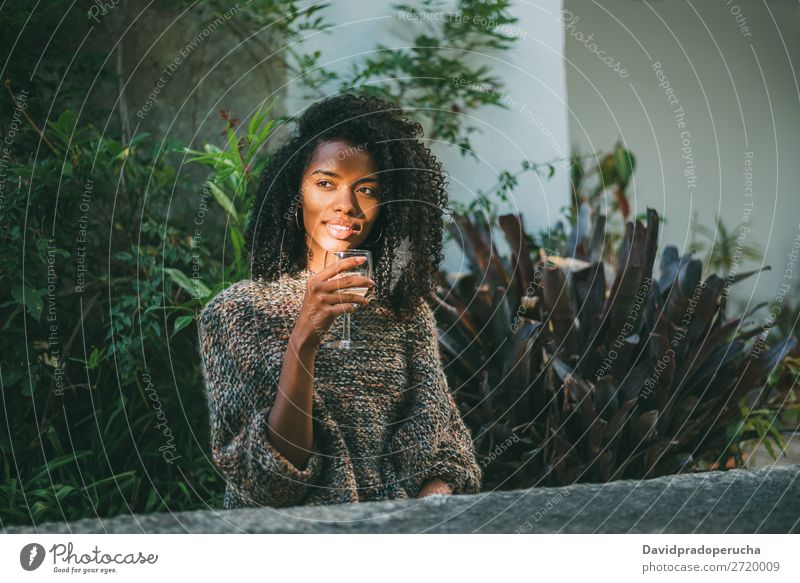 Woman in a countryside house garden drinking wine Ethnic 1 black woman Home Attractive Adults Rural Considerate Beautiful Glass Wine Winter Curly
