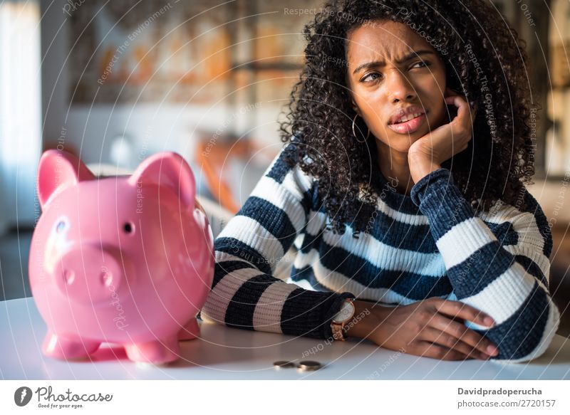 Thoughtful confused black woman with piggy bank Woman Money box Considerate debt Crisis Expression Irritation mistake Sadness Budget worried disappointed