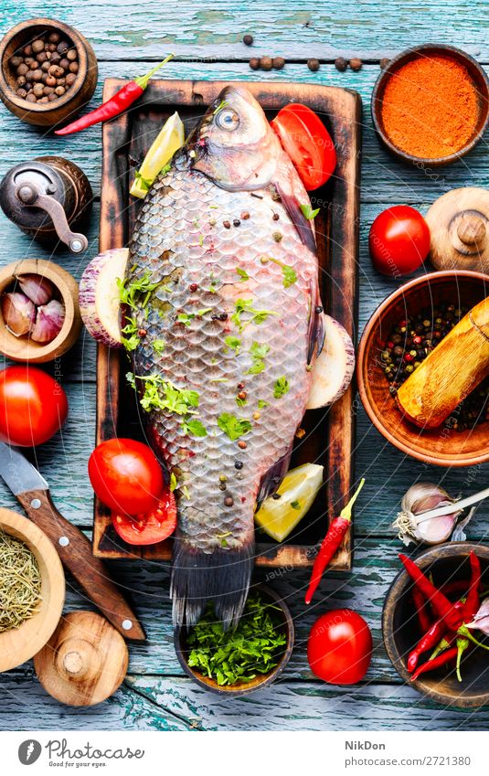 Fresh fish and food ingredients raw carp seafood raw fish fresh meal healthy cutting board cooking pepper tomato vegetable preparation spice salt diet uncooked