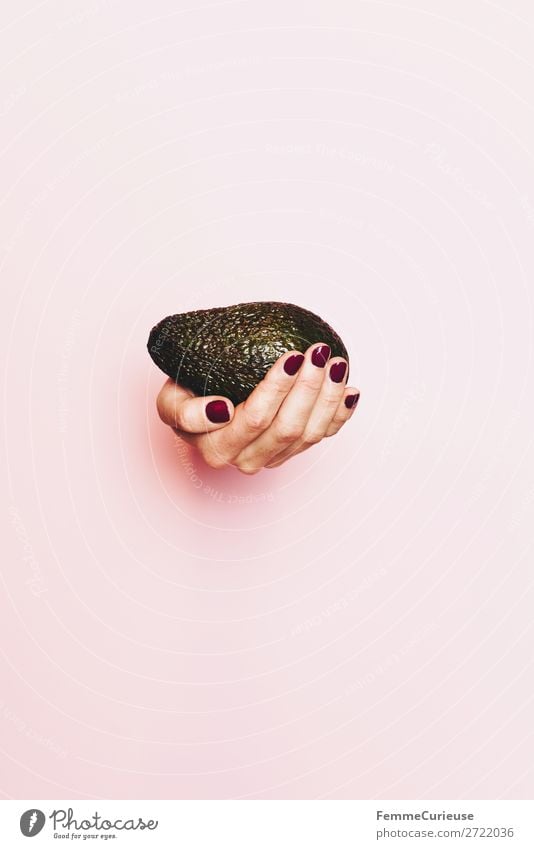 Hand of a woman holding an avocado Food Nutrition To enjoy Healthy Eating Vegetarian diet Vegan diet Avocado To hold on Pink Nail polish Feminine Vitamin