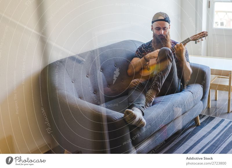 Man playing guitar in armchair Home Relaxation Adults bearded Sit Armchair Playing Guitar Musician Acoustic Easygoing Youth (Young adults)