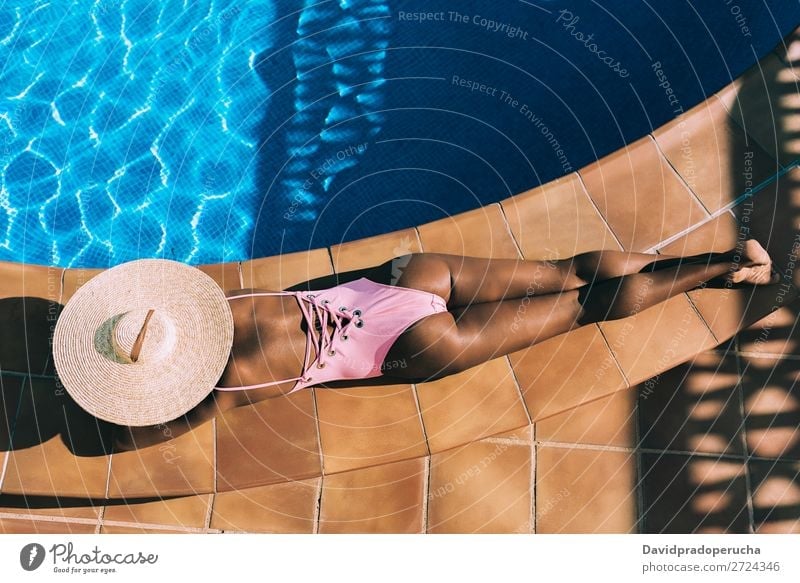 Black woman lying down in a swimming pool side Woman Ethnic Swimming pool Summer Sunbathing Vacation & Travel tan Horizontal tanning Relaxation Copy Space