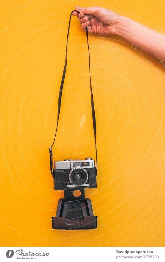 Hand holding a Vintage camera isolated at orange wall Arm Camera Orange Wall (building) Retro Old Isolated Studio shot Hold Leisure and hobbies Illustration