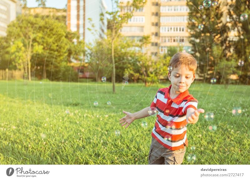 Happy boy playing with soap bubbles in the park Lifestyle Joy Beautiful Relaxation Leisure and hobbies Playing Freedom Summer Garden Child Human being