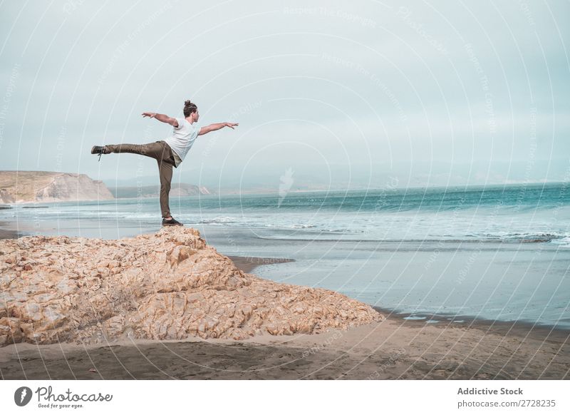 Man balancing on rock of ocean Rock Ocean Balance Calm Freedom Stand Peace Yoga Relaxation Concentrate Beach Nature Exterior shot Summer Athletic Healthy