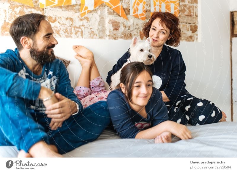 Couple relaxed at home in bed with their little daughter and the dog Affection Bed Bedroom Wife Husband Daughter Child Small Dog Pet Puppy mum dad Parents