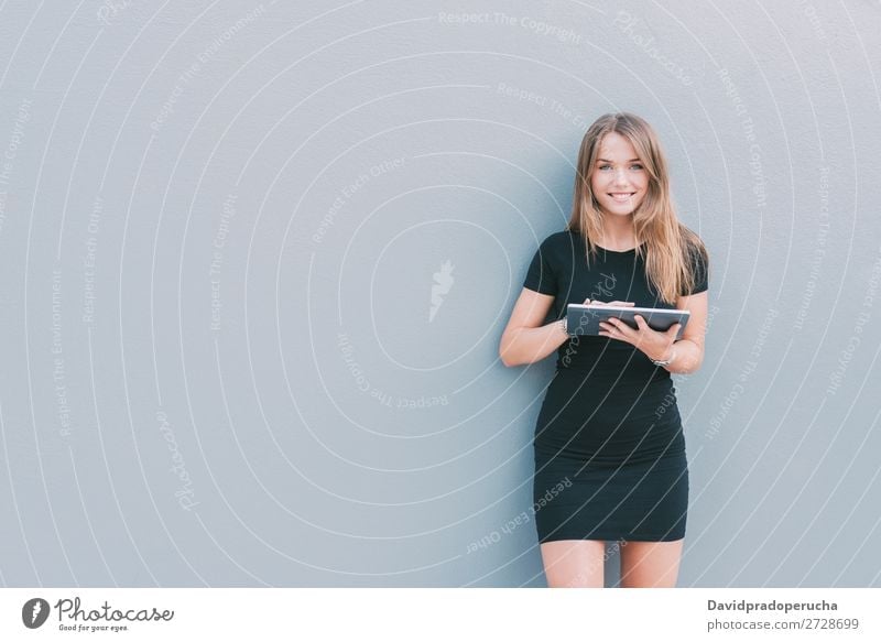 Happy young woman on the tablet by the wall Woman Isolated Blonde Tablet computer Technology Coffee Youth (Young adults) Black Dress Beauty Photography City